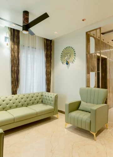 Living room interior with green chesterfield sofa and gold finishes