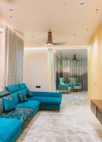 Living room interior with teal sectional sofa and wooden wall panels
