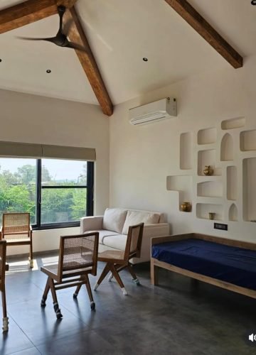 Living room with sloped wooden roof beams and wall niches